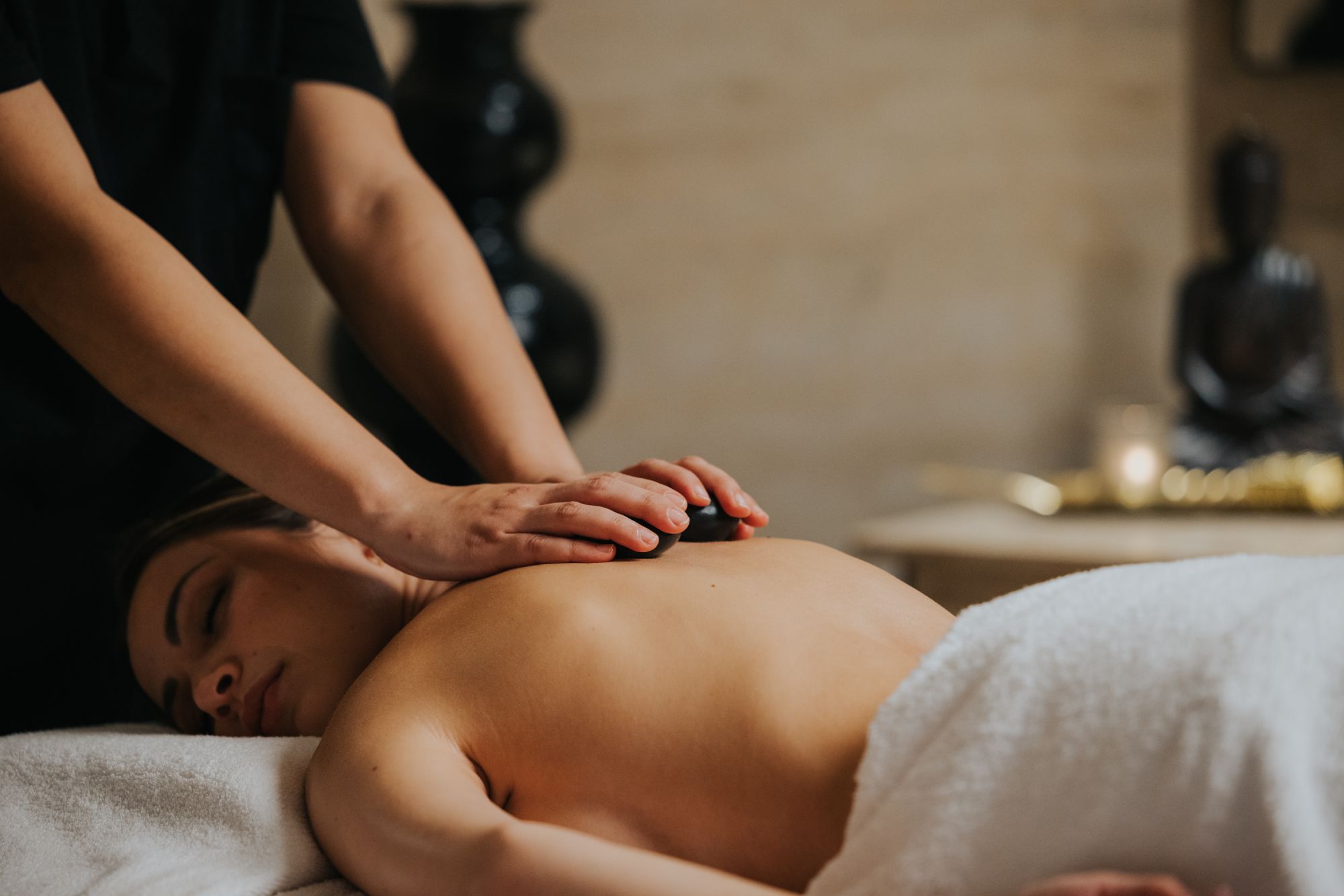 woman enjoying a hot stone massage during her stay at Xemxija Bay Hotel in Malta